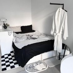 a bedroom with a black and white checkerboard floor, an ironing board on the wall