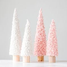 three small pink and white trees on wooden sticks