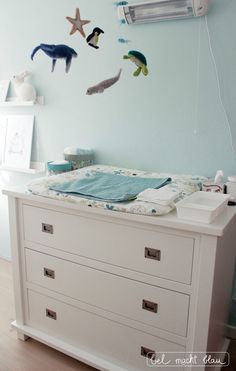 a baby's crib with sea animals on the wall