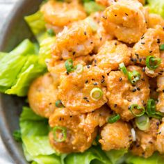 a close up of a bowl of food with lettuce and sauce on it