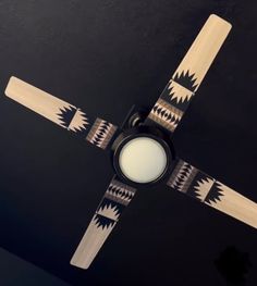 a ceiling fan with an intricate design on it's blades and light bulb in the center