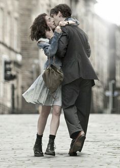 a man and woman kissing on the street