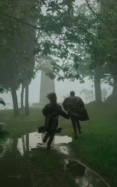 two people are walking in the rain with umbrellas