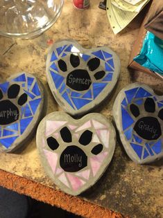 three painted rocks with words on them that spell out the word gradly and two paws in the shape of hearts