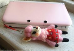 a small stuffed animal laying next to a pink laptop