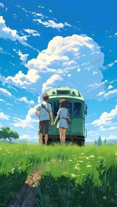 two people standing in front of a train on a grassy field under a cloudy blue sky