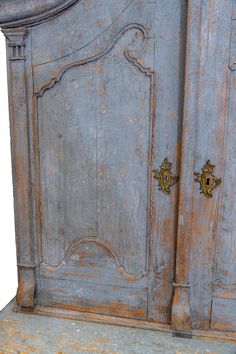 an old wooden armoire with two brass handles