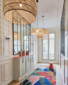 a colorful rug in the middle of a room with chandeliers hanging from the ceiling