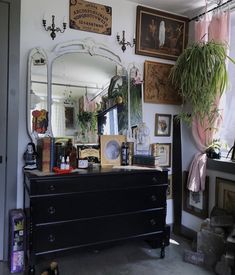 an instagram photo of a dresser and mirror in a room with pictures on the wall