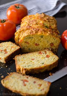 sliced bread with tomatoes on the side and text overlay that reads herb tomato quick bread