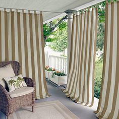 a chair sitting on top of a wooden floor next to a window covered in curtains