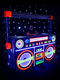 a man standing in front of a boombox with lights on it's sides