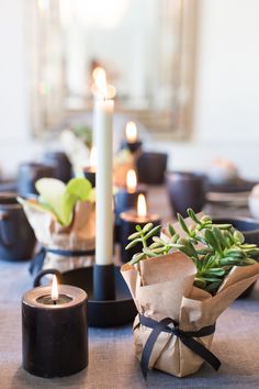 a table topped with candles and vases filled with flowers