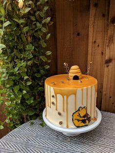 a yellow and white cake sitting on top of a table next to a wooden fence