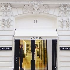 the entrance to a chanel store with two men standing in it's doorway