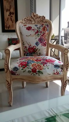 an ornate wooden chair with floral upholstered fabric on the armrests and back