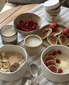 bowls of oatmeal, fruit and yogurt are on the table