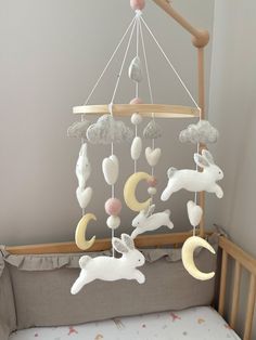 a baby crib with an animal mobile hanging from it's side