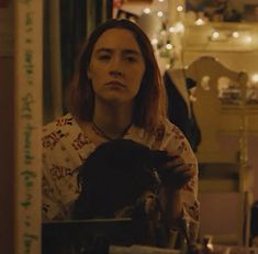 a woman is combing her hair in a room with christmas lights on the walls