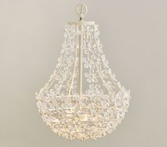 a white chandelier hanging from the ceiling with crystal beads and leaves on it