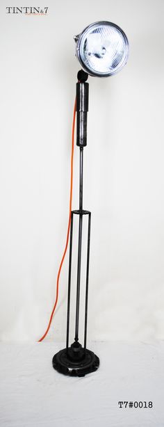 a light that is sitting on top of a stand with an orange cord attached to it