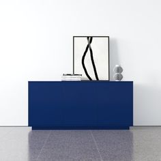 a blue sideboard with a black and white painting on the wall next to it