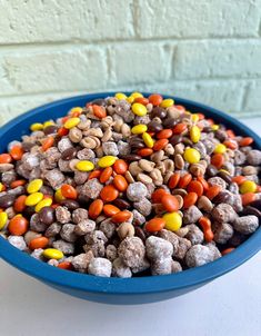 a blue bowl filled with candy corn and peanuts