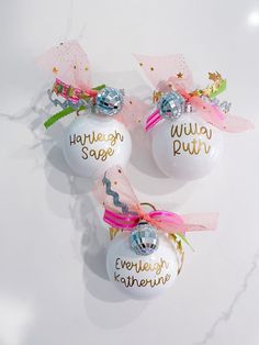 three personalized christmas ornaments with bows on them