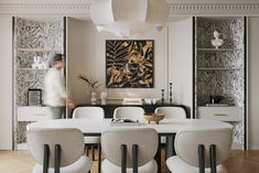 a dining room with white chairs and a large painting on the wall