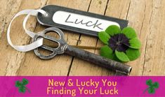 an old pair of scissors sitting on top of a wooden table next to a clover