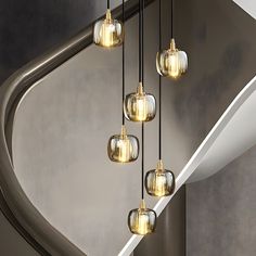 a bunch of lights that are hanging from the ceiling in front of a spiral staircase