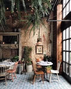 an indoor dining area with brick walls and potted plants