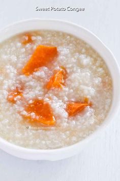 a white bowl filled with oatmeal and carrots on top of a table