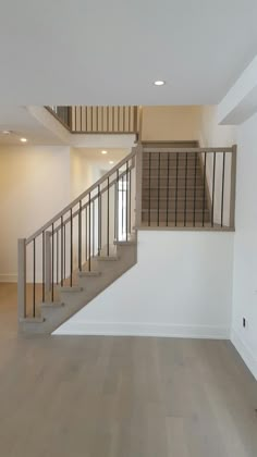 an empty room with white walls and wooden stairs