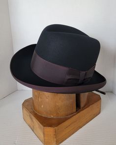 Elevate your style with this beautiful vintage Dobbs elegant homburg hat. Crafted from high-quality materials, this hat is the perfect addition to any wardrobe. With its classic design and versatile color, make it a must-have for any fashion-forward individual who wants to make a statement. Its timeless design and superior craftsmanship ensure that it will be a staple in your wardrobe for years to come. Invest in this vintage accessory today and add a touch of sophistication to your look. This b Vintage Navy Hat With Flat Brim, Vintage Blue Flat Brim Hat, Vintage Brown Brimmed Fedora, Homburg Hat, Men's Fedoras Hats Over $275.00, Homburg, Hat Blocks, View Pictures, Visual Arts