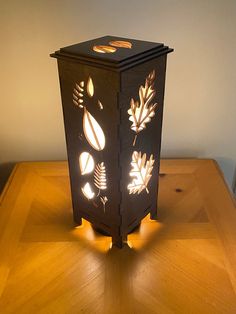 a lit up lantern sitting on top of a wooden table