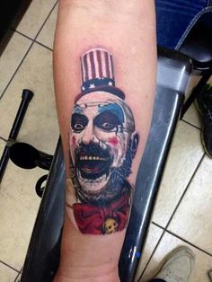 a man's arm with a tattoo on it that has an image of a clown