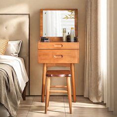 a bedroom with a bed, mirror and stool in the corner next to a window