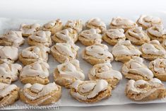 a bunch of cookies with icing on top of them sitting on a paper towel