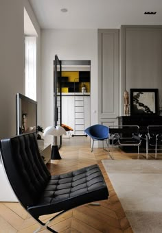 a living room filled with furniture and a flat screen tv on top of a wooden floor