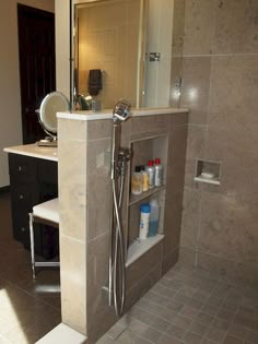 a bathroom with a sink, shower head and shelves on the wall next to it