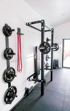 a home gym with black and white equipment on the wall next to an open door