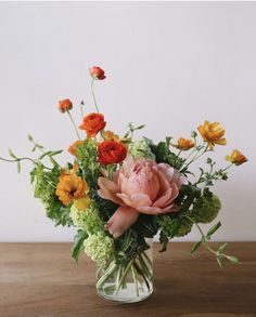 a vase filled with lots of different colored flowers