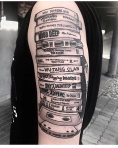 a black and white photo of a man's arm with stacked books on it