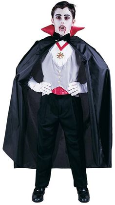 a young boy dressed in dracula costume standing with his hands on his hips and mouth open