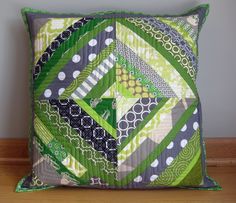 a green and gray pillow on top of a wooden table