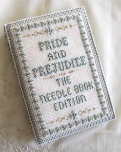 a cross stitch book with the words pride and protection on it sitting on a bed