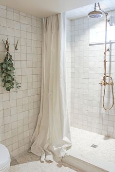 a bathroom with a shower and white tiled walls