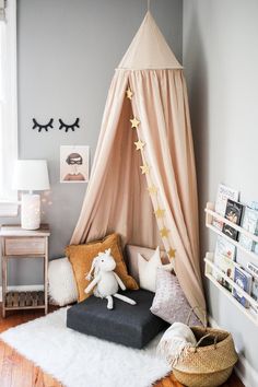 a child's bedroom with a teepee tent and pillows