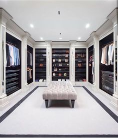 a large walk in closet with white walls and black flooring